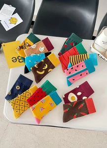 Flat lay of colorful cotton crew socks featuring diverse animal and fruit jacquard patterns