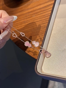 Detail of rose gold double-layer bracelet with pink shell wulu charms and zircon inlay