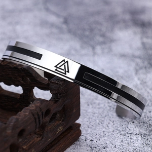 Silver and black stainless steel Viking Valknut rune cuff bracelet on wooden stand