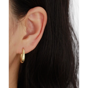Close-up of golden brushed finish S925 silver hoop earring worn on a model's ear