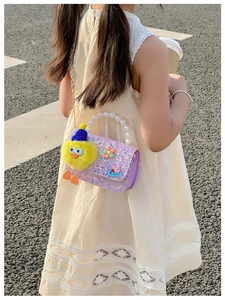 Girl's purple sequin crossbody bag featuring pearl handle and cute plush charm