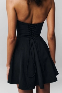 Dettaglio dell'allacciatura a corsetto sulla schiena di questo mini abito nero
