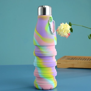Detail of rainbow tie-dye collapsible silicone water bottle with metal lid and carabiner