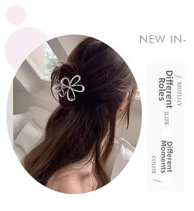 Détail de la pince à cheveux fleur argentée ajourée sur cheveux longs mi-attachés