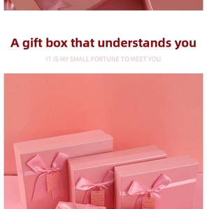 Close-up of coral pink gift boxes with silk bows and elegant handwritten tags