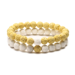 Detail of yellow and white volcanic stone beaded bracelets with natural porous texture