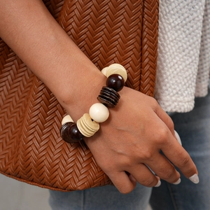 Detailed close-up of beaded wooden bracelet with ivory and dark brown geometric coconut beads