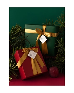 Deep red and forest green Christmas gift boxes with gold ribbons and festive tags