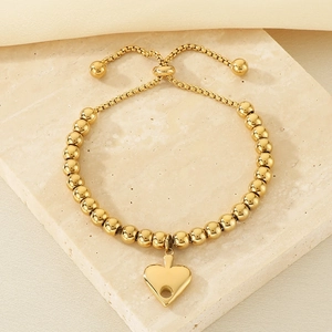 Detail of 18K gold-plated stainless steel bead bracelet with a heart charm and adjustable clasp