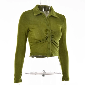 Detail of green long sleeve cropped top with lapel collar and buttoned pleated fabric