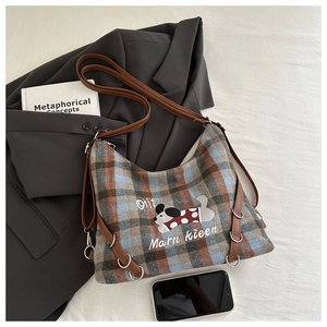 Flat lay of plaid tote bag with cute dog print on grey blazer and white background