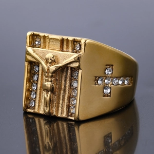 Macro detail of gold-plated religious ring with Jesus relief and zircon crosses