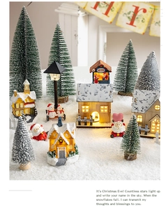 Luminous Christmas miniature village display with candy store glowing cabin and warm lights