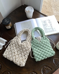 Handwoven cream and mint green knit tote bags on a rustic wooden table setting