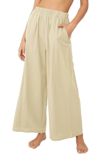 Gros plan sur la taille haute élastique et le tissu en lin beige du pantalon large