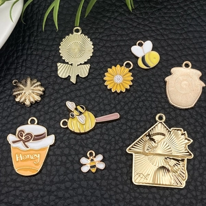 Detailed view of eight alloy enamel bee and honeycomb pendants for jewelry making