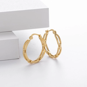 Detailed macro view of S925 sterling silver stamp on golden hollow geometric hoop earrings