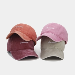 Detail of washed cotton baseball caps showing 'Everyday' embroidery in multiple colors