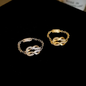 Macro detail of gold and silver knot rings with pavé cubic zirconia on black velvet