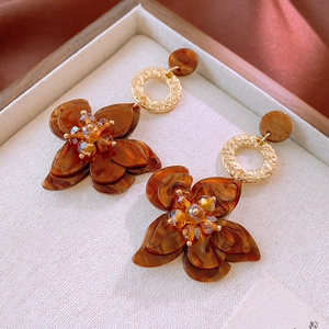 Detailed shot of vintage amber resin flower earrings with gold ring and crystal core