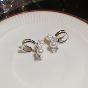 Macro detail of silver ear cuff featuring multiple white pearls and cubic zirconia accents