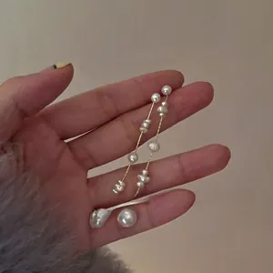 Detail of French chic baroque pearl tassel earrings with delicate gold chain drop
