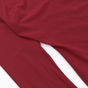 Gros plan sur la double couture et la maille de cette robe moulante rouge foncé