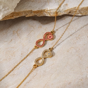 Macro detail of infinity pendant necklace with pink and clear cubic zirconia stones