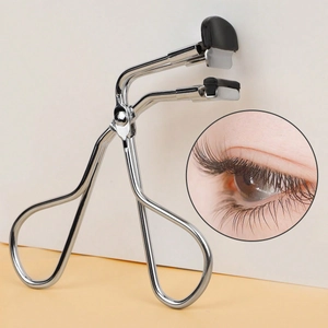 Detail view of mini stainless steel eyelash curler with soft black rubber pad for curling