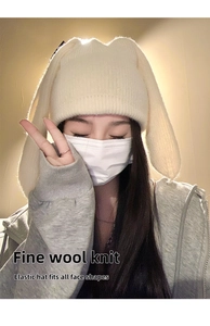 Detailed knit texture of a cream bunny ear beanie with a flexible, warm winter fit