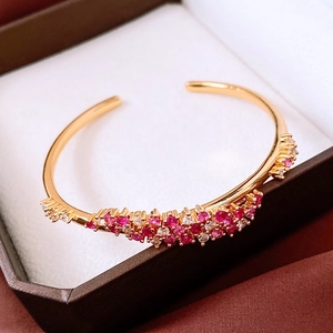 Détails macro d'un bracelet vague plaqué or 18 carats serti de pierres précieuses