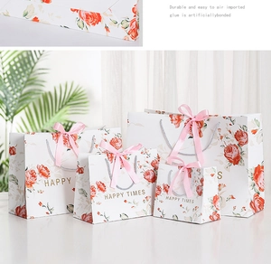 Detail of floral paper gift bags with pink ribbon bows and festive rose pattern design