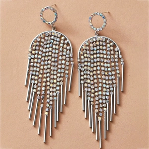 Close-up of silver-toned fringe earrings with iridescent rhinestones and metallic tassels