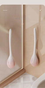 Detail of drop-shaped wall-mounted toilet brush with pink and white gradient finish