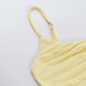 Close-up of adjustable strap and metal buckle on pale yellow backless summer top