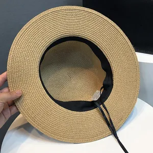 Detailed view of straw hat interior showing adjustable drawstring and sweatband texture