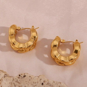 Detail of twisted chunky 18K gold plated stainless steel hoop earrings on silk