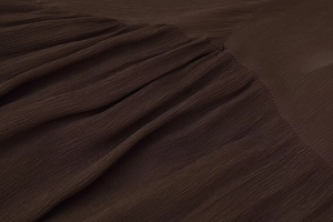 Gros plan détaillé du tissu mousseline froissé marron foncé avec texture élégante