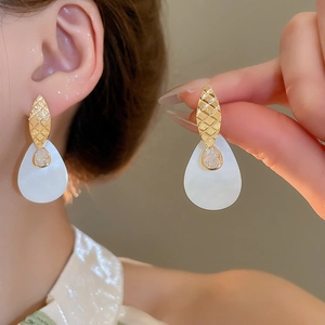 Dettaglio di orecchini a goccia placcati oro 24k con zircone e madreperla in stile elegante