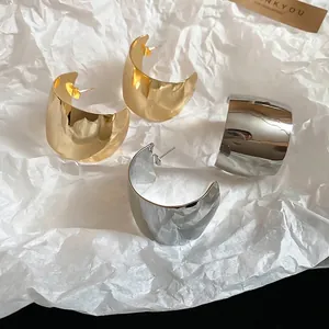 Polished chunky C-shaped hoop earrings in gold and silver finish for a minimalist look