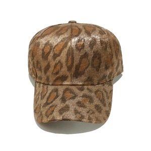 Detailed close-up of brown leopard print baseball cap with metallic gold foil finish
