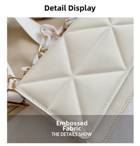 Close-up of beige crossbody bag showing embossed geometric fabric and gold chain strap