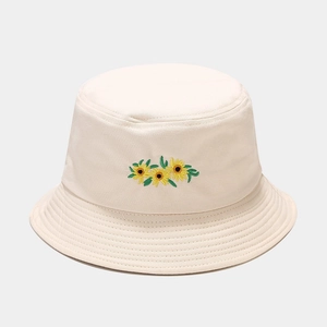 Détail de la broderie tournesol sur chapeau bob en toile blanc crème avec bord surpiqué
