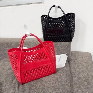 Close-up of red and black hollow jelly handbags with woven silicone grid texture