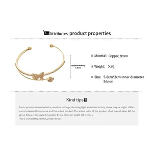 Detail of gold-plated double-layer cuff bracelet with zircon butterfly and clover charms