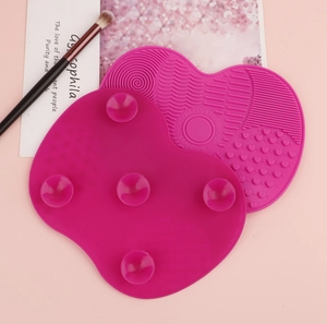 Macro detail of heart-shaped silicone makeup brush mat with suction cups and textures