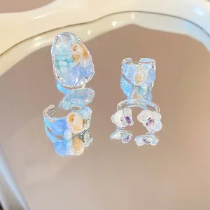 Exquisite silver-toned beaded rings with natural shells and blue gemstones on mirror