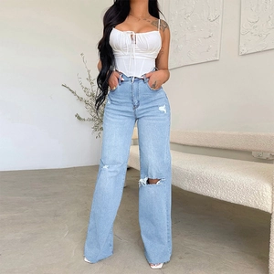 Dames set met witte korsettop en lichtblauwe high waist jeans met wijde pijpen en gaten