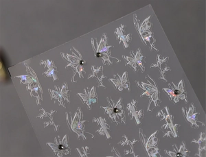 Vue macro de stickers d'ongles papillon 3D avec motifs bambou et petits strass noirs
