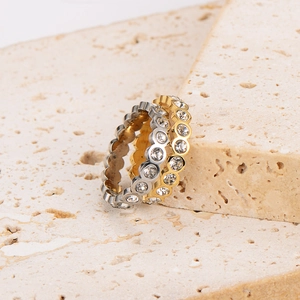 Minimalist gold and silver stainless steel rings with zirconia on beige stone base